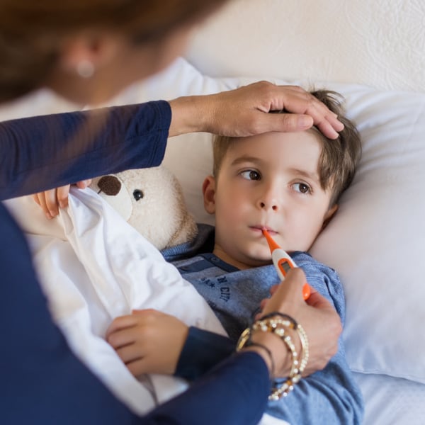 A mother checks her child for fever