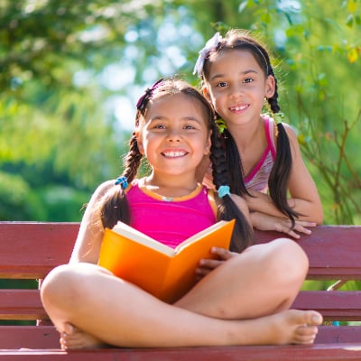 Latina sisters on a park bench